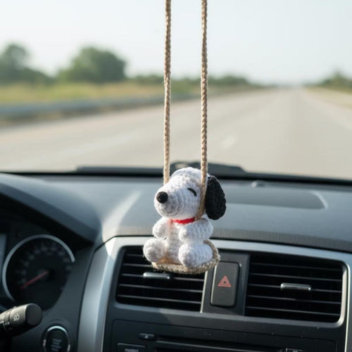 Car dashboard with a plush dog toy hanging from the rearview mirror.